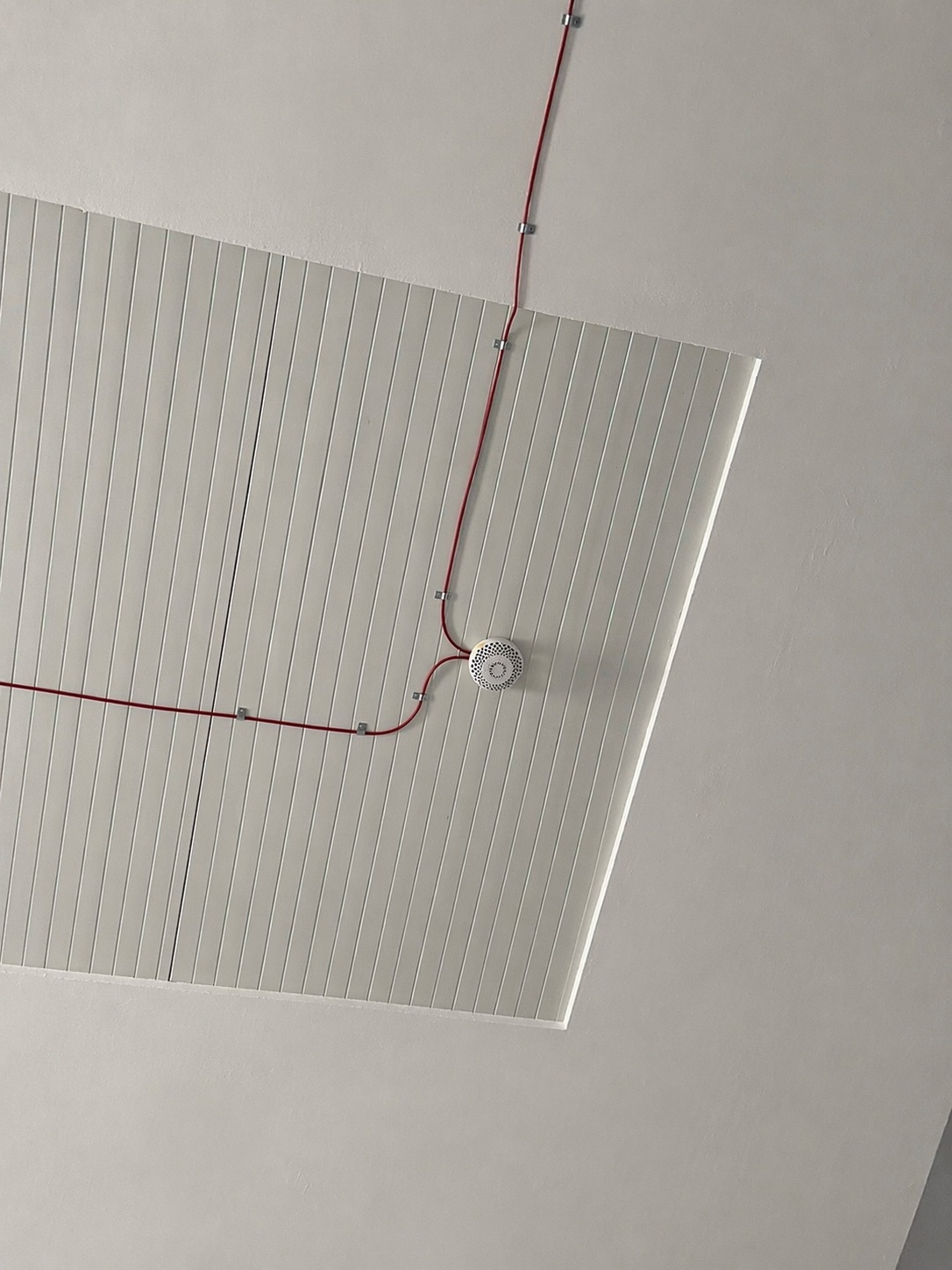 Prowadzenie czerwonej instalacji na suficie z osprzętem alarmowym